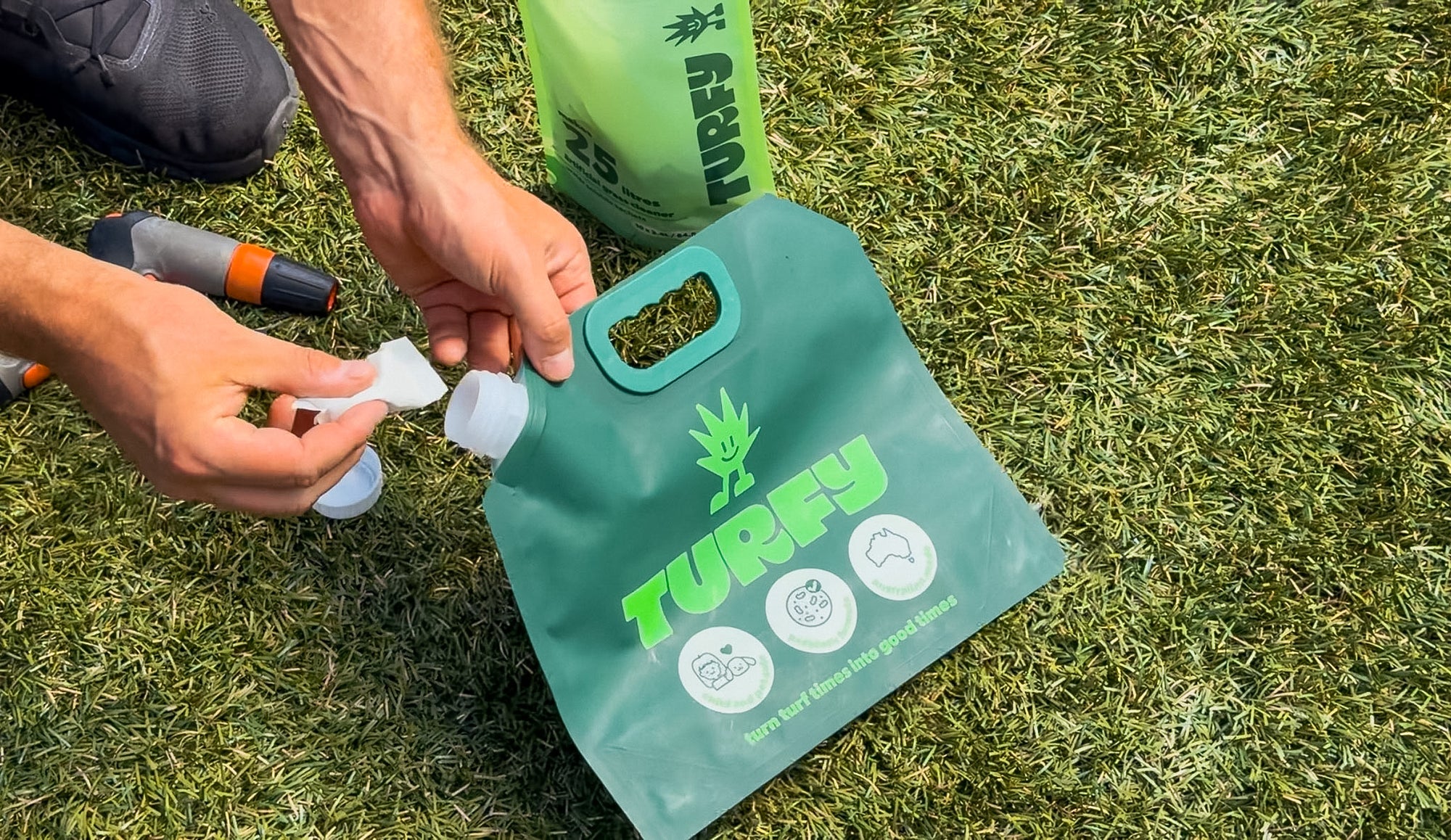 man putting dissolvable sachet probiotic turf cleaner-into 2.5l pouch on grass